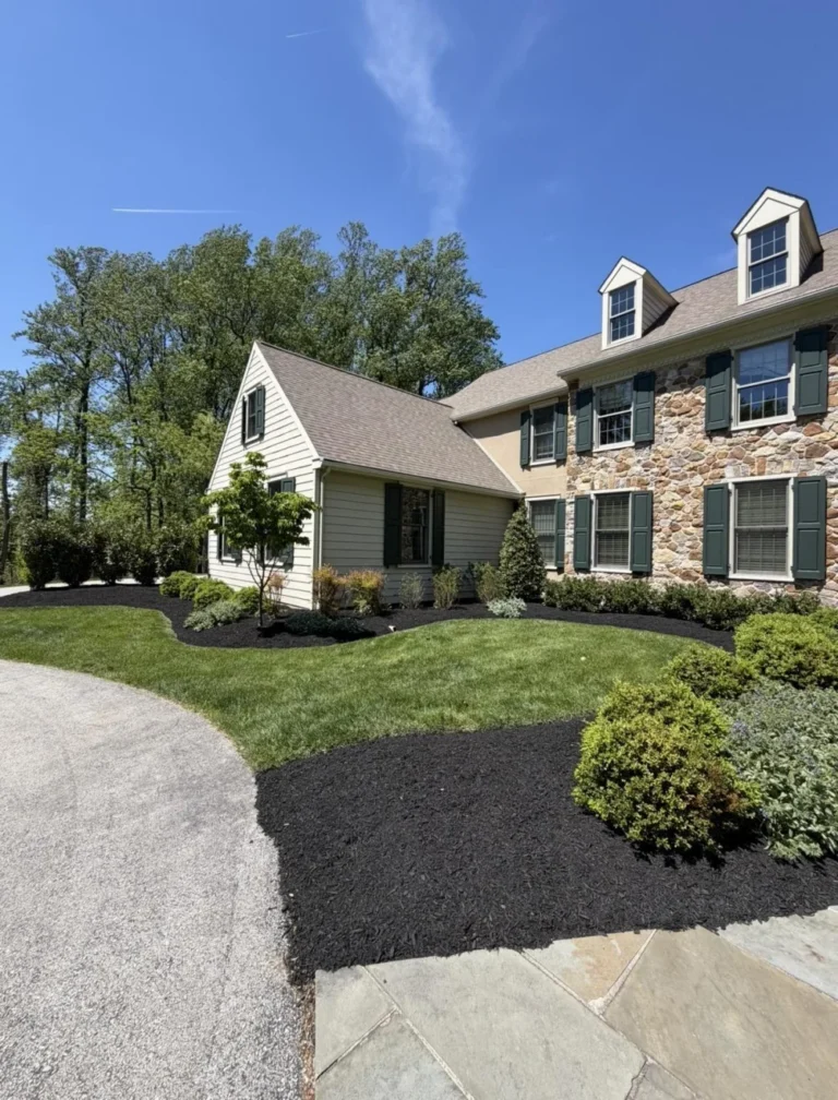 Fresh black mulch installed along a foundation flower bed